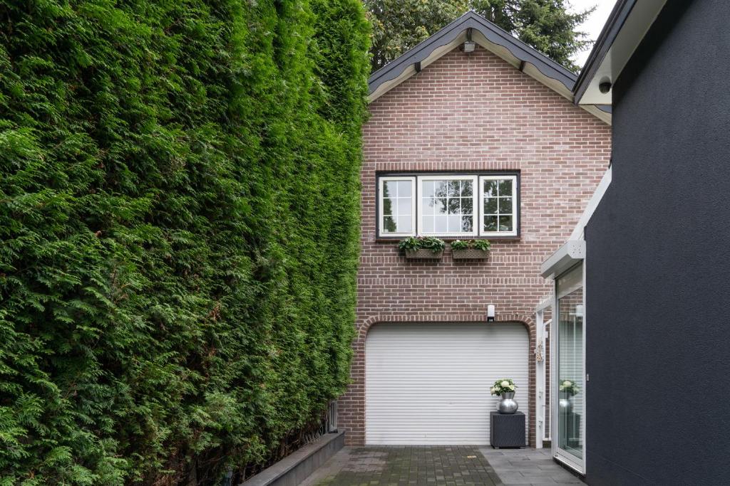 une maison couverte de lierre avec un garage dans l'établissement CENTRUM-MARIASTRAAT-APELDOORN, à Apeldoorn