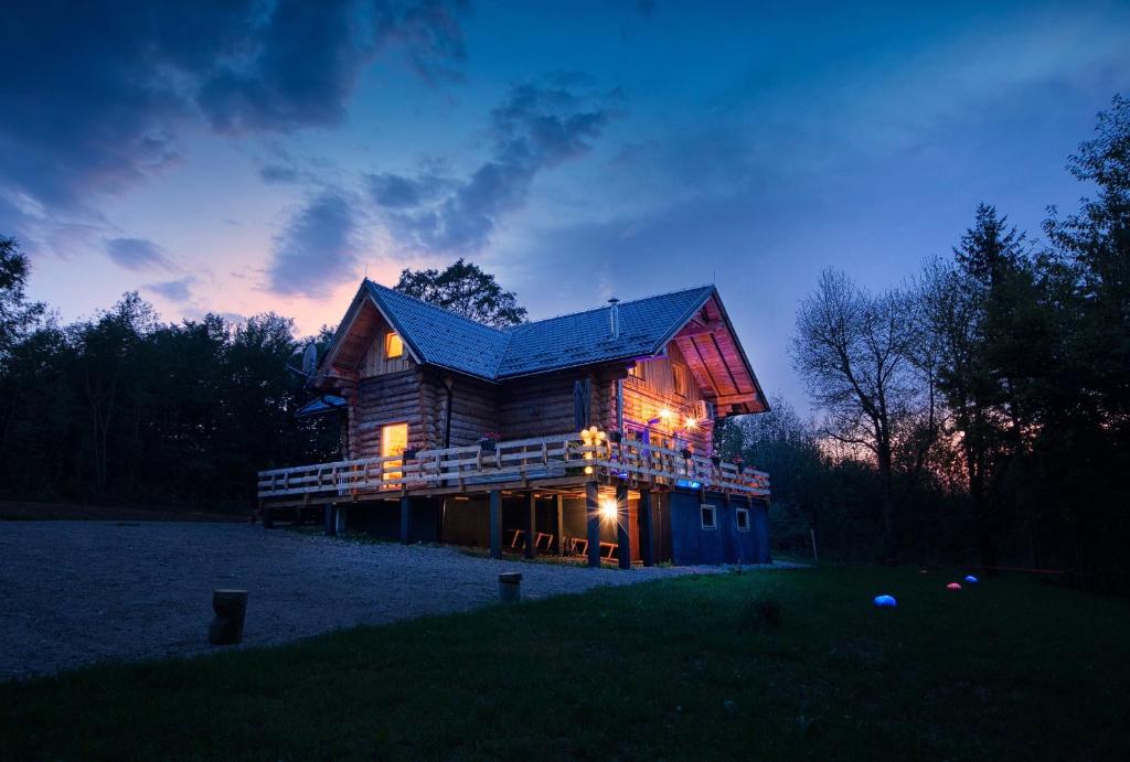 a large log cabin at night with the lights on at WOODS LODGE PLITVICE LAKES in Drežnik Grad