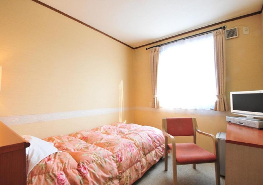 Schlafzimmer mit einem Bett, einem Schreibtisch und einem TV in der Unterkunft Omura - Hotel / Vacation STAY 46222 in Omura