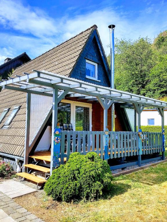 a blue house with a white fence and a porch at Ferienhaus Giebelei in Medebach