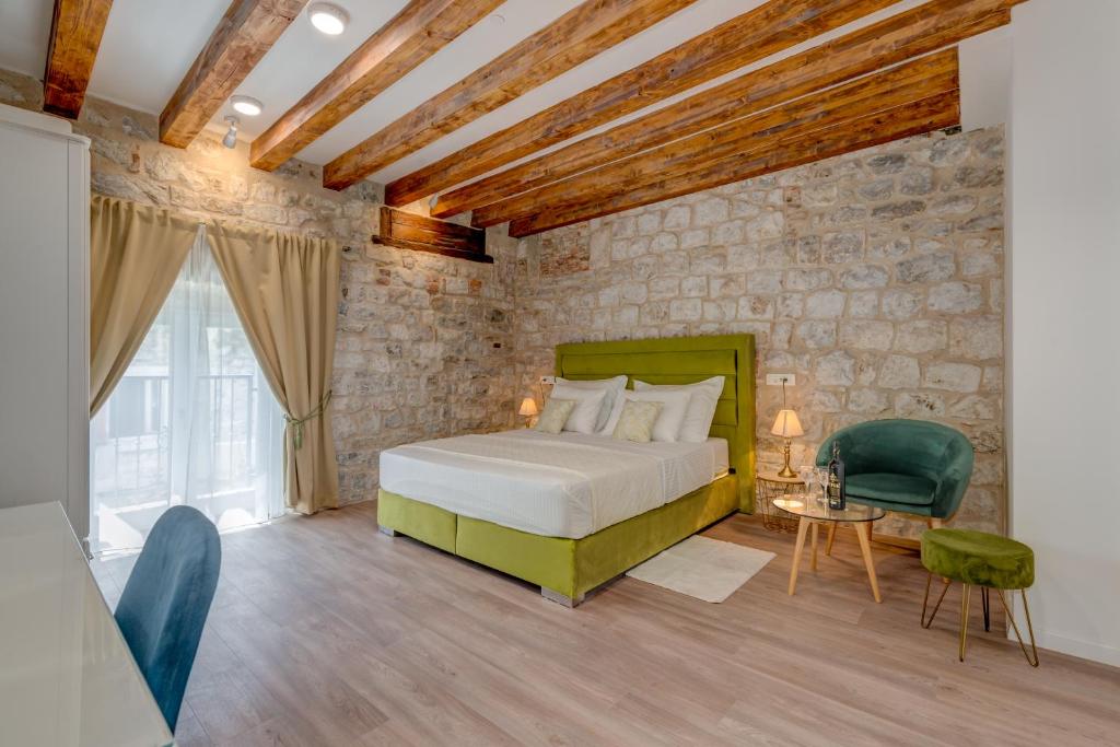 a bedroom with a bed and a stone wall at Princ Heritage Rooms in Split