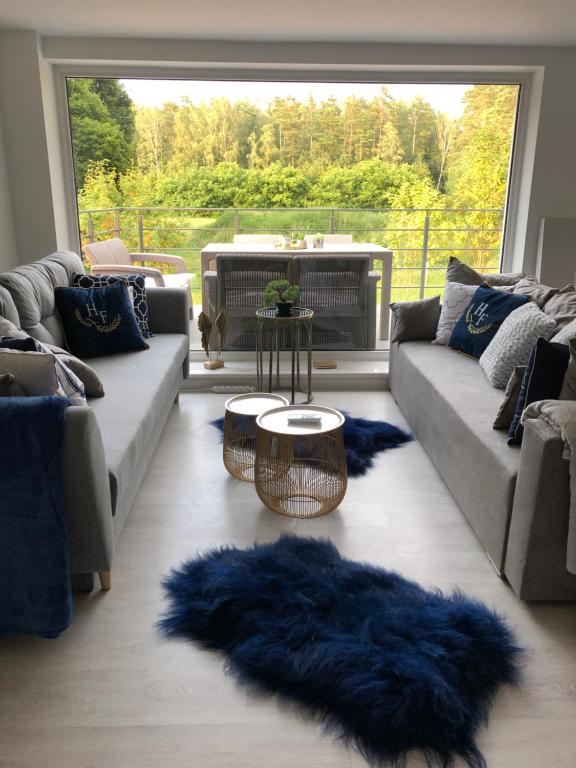 uma sala de estar com sofás e um tapete azul em Comfort Zone Ostróda Ruś Mała em Ostróda