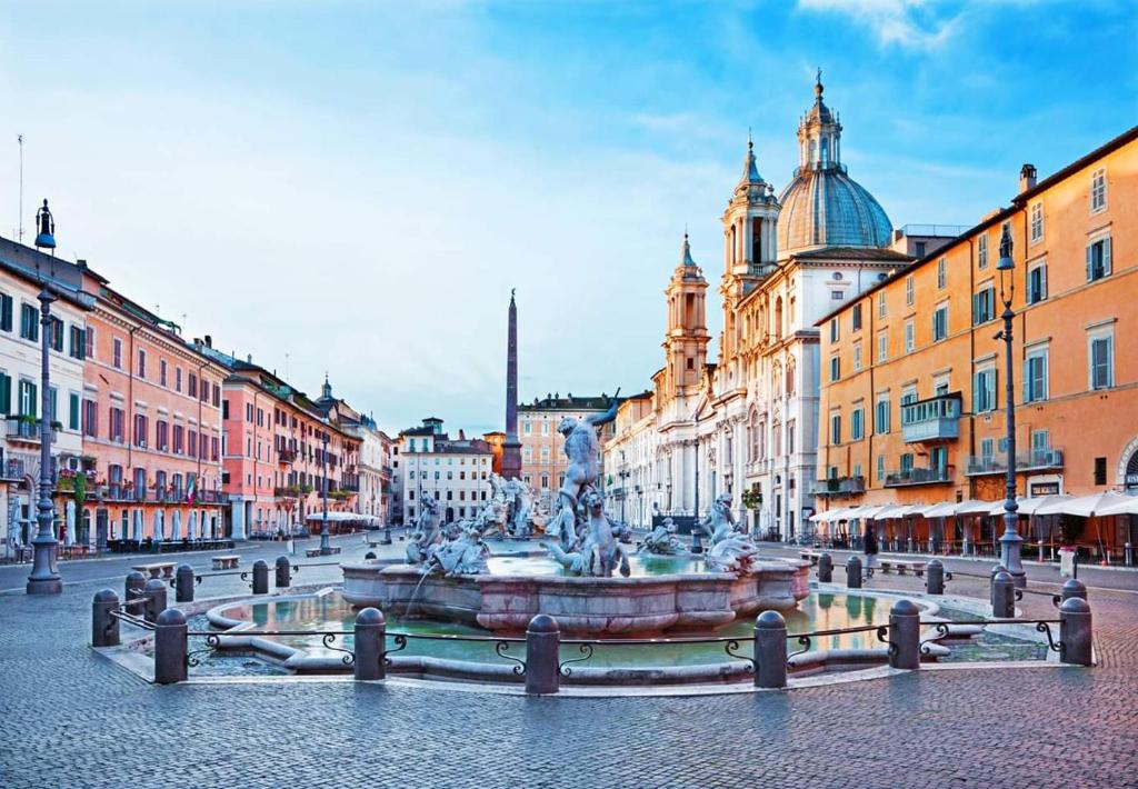 een fontein in het midden van een straat met gebouwen bij old corallo in Rome