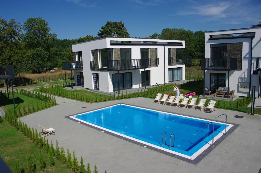 a house with a swimming pool in front of a house at Rayo del Sol Łukęcin in Łukęcin