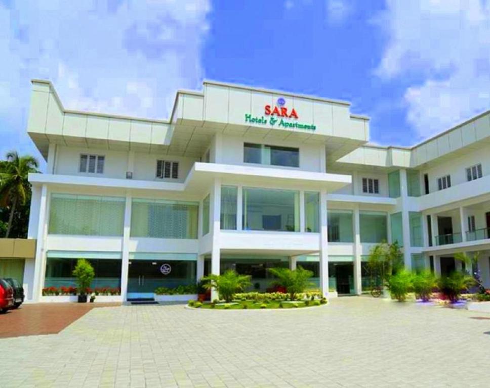 a large white building with a sana sign on it at Sara Hotels and Apartments in Nedumbassery