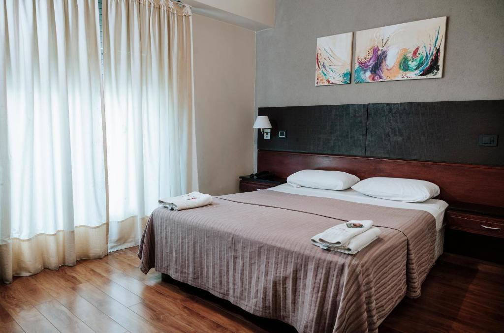 a bedroom with a bed with two towels on it at Tucuman Palace Hotel in Buenos Aires