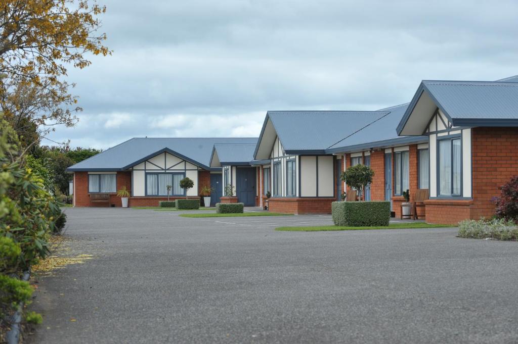 a row of houses in a driveway at Tudor Lodge Motel in Hawera