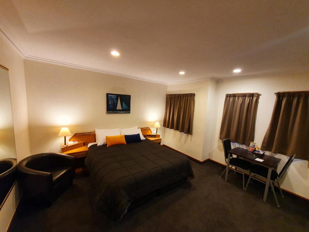 a hotel room with a bed and a desk at Fitzherbert Castle Motel in Palmerston North