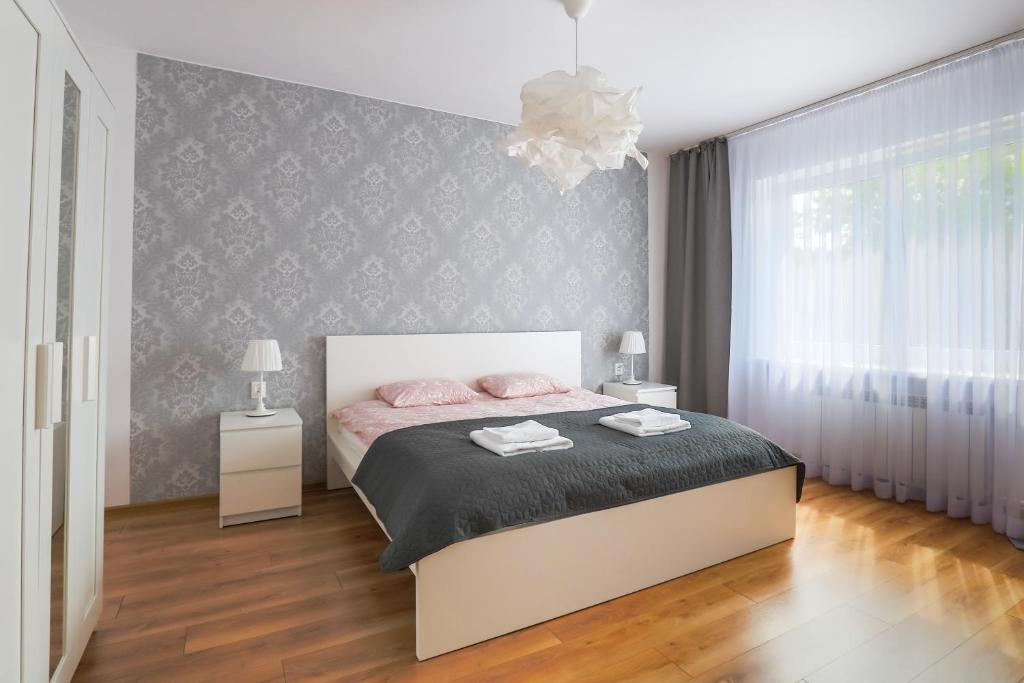 ein Schlafzimmer mit einem großen Bett mit rosa Bettwäsche in der Unterkunft Apartament Pod Winogronami in Krakau