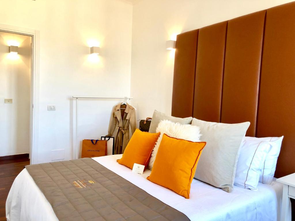 1 dormitorio con 1 cama con almohadas de color naranja y blanco en Heart Palace Fontana di Trevi, en Roma