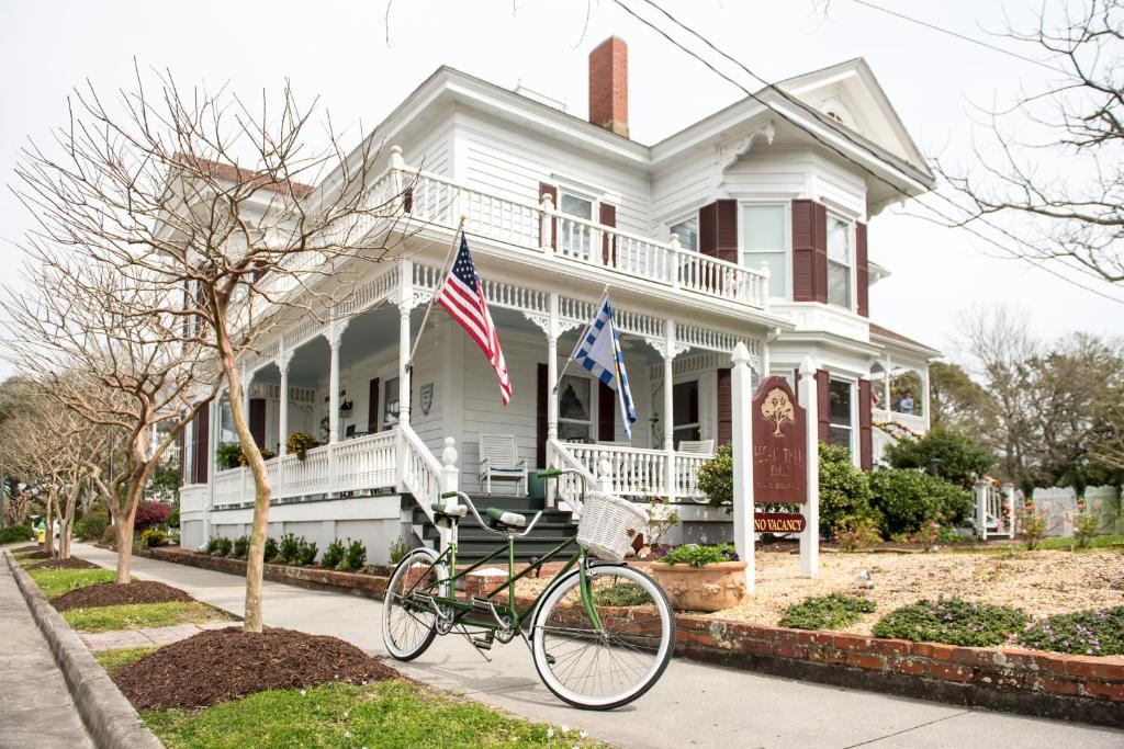 een fiets geparkeerd voor een wit huis bij Pecan Tree Inn in Beaufort
