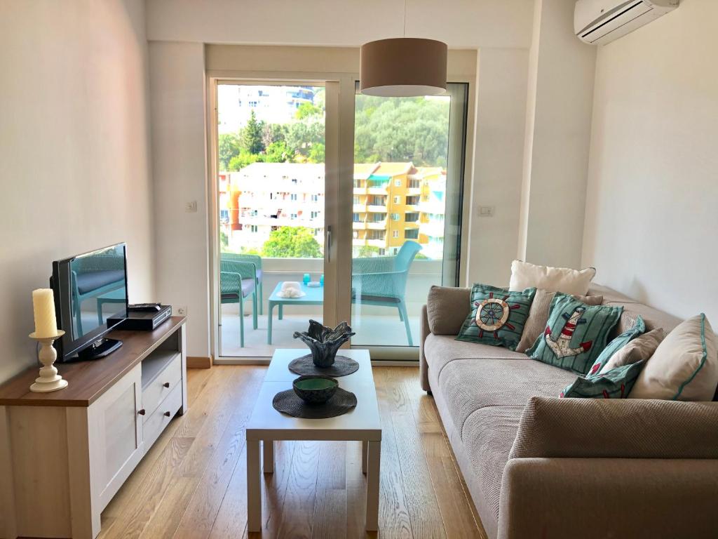 a living room with a couch and a tv at Marina Residence in Becici