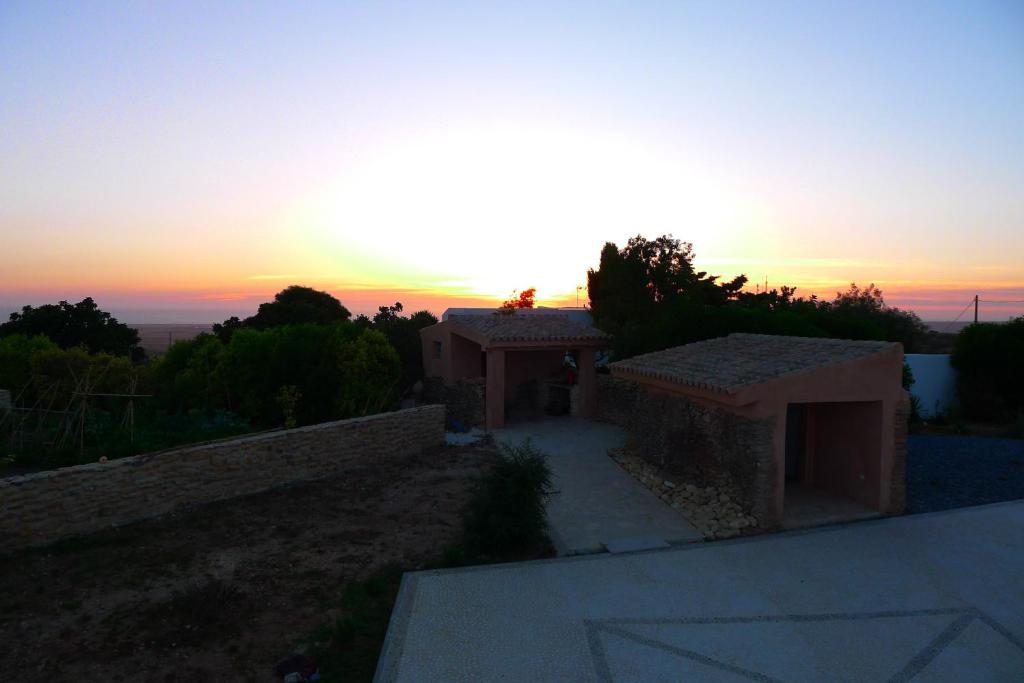 ベヘール・デ・ラ・フロンテーラにあるFinca du ressourcement Higueronの夕日を背景にした家