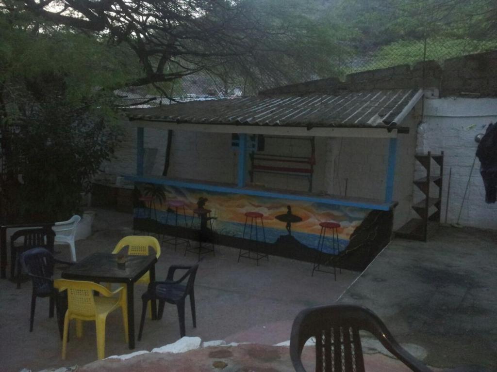 a patio with a table and chairs and a building at El Garaje Hostal in Taganga