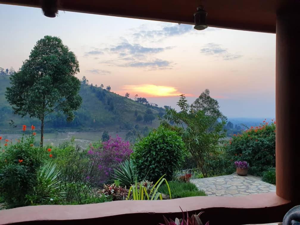 a view from a window of a garden with a sunset at Nyore Hillside Retreat in Mbarara