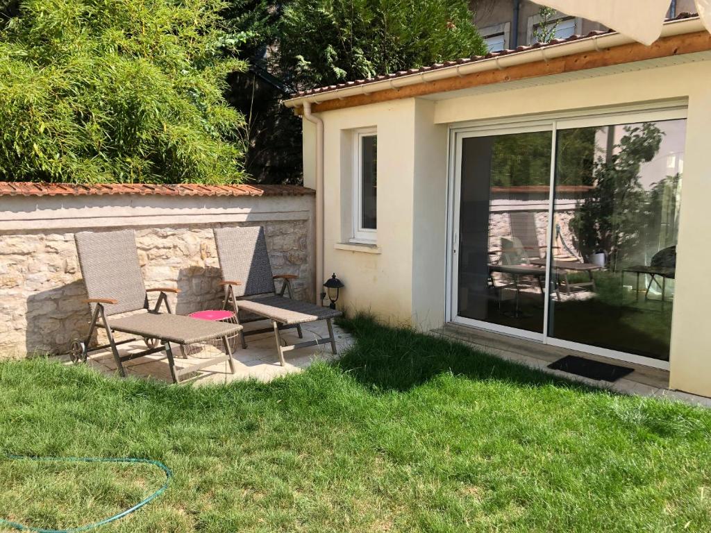 a patio with two chairs and a bench in the grass at studio maisonnette avec jardin, Nancy Thermal, Artem in Nancy