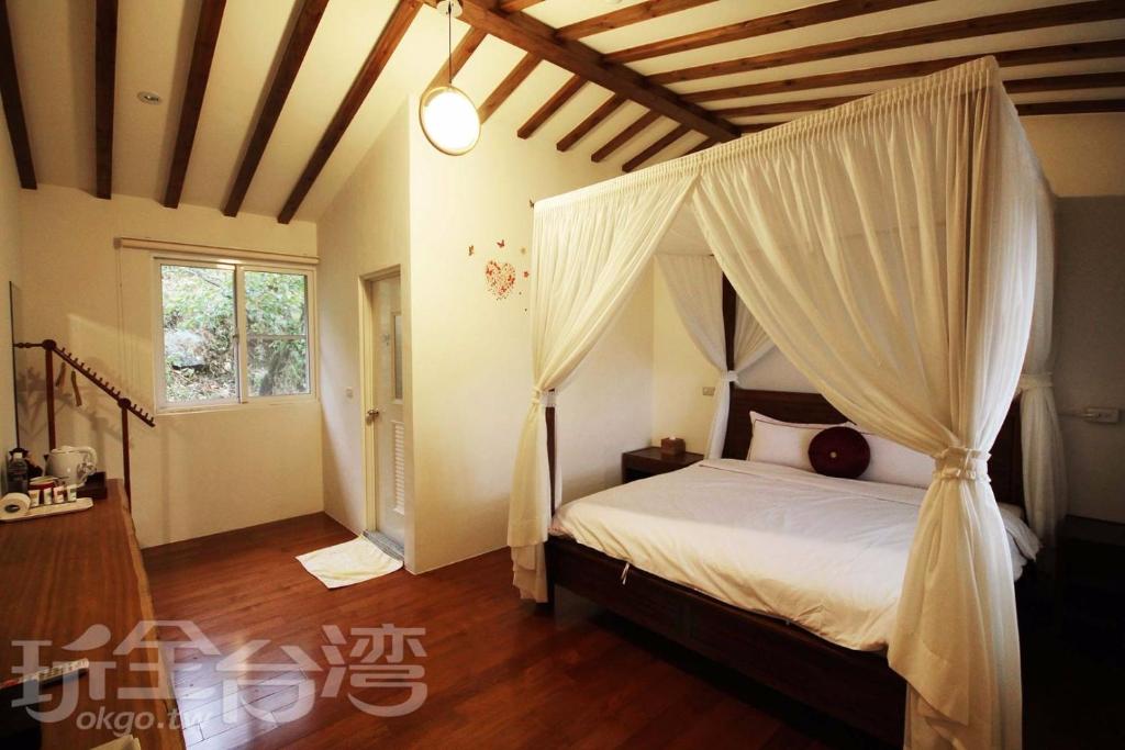 a bedroom with a bed with a canopy at SunRise 23.5N B&B in Fenchihu