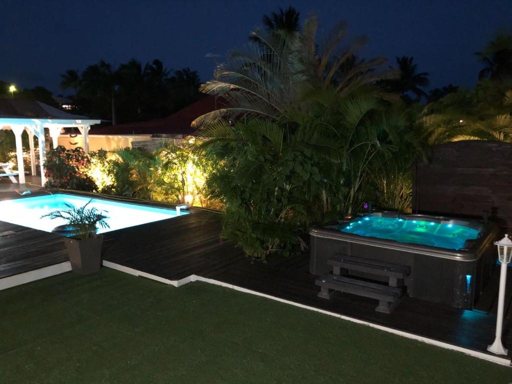 un patio trasero con piscina y bañera de hidromasaje en Villa SoFi, en Saint-François