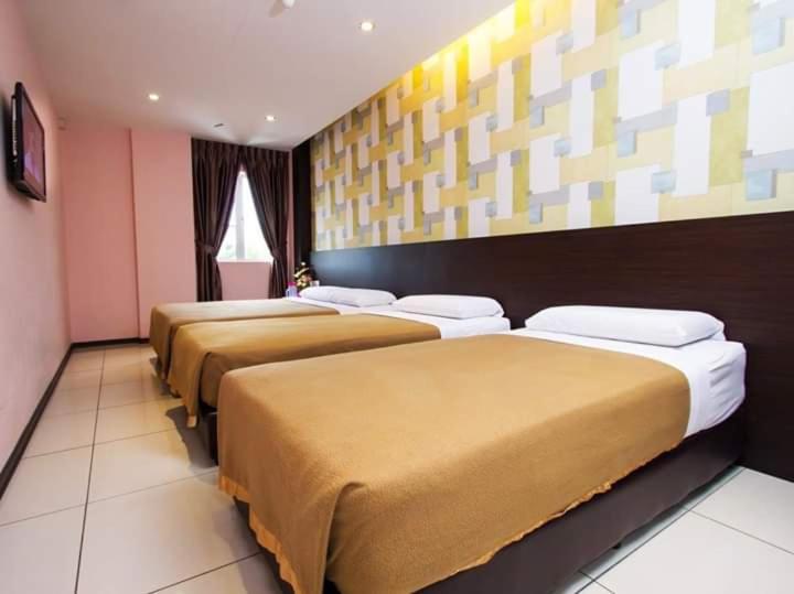 Postel nebo postele na pokoji v ubytování Remember Hotel Bukit Gambir