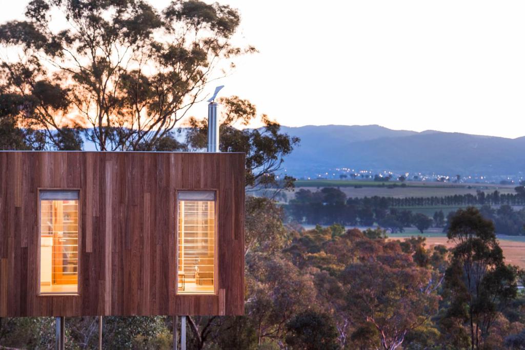 a house on the side of a hill with two windows at Strikes Mudgee in Eurunderee