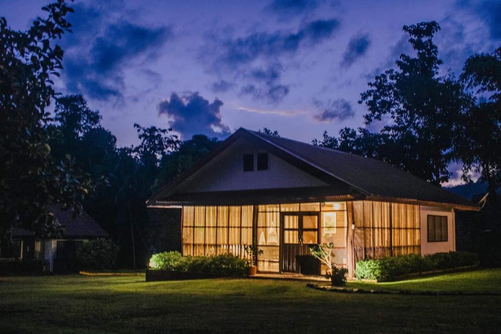 a house lit up at night in a yard at The Cabins at LVF in Puerto Princesa City