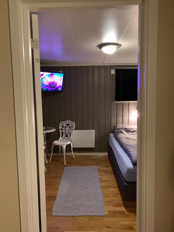 1 dormitorio con 1 cama y TV en la pared en Cozy & private room in the middle of Lofoten, en Leknes