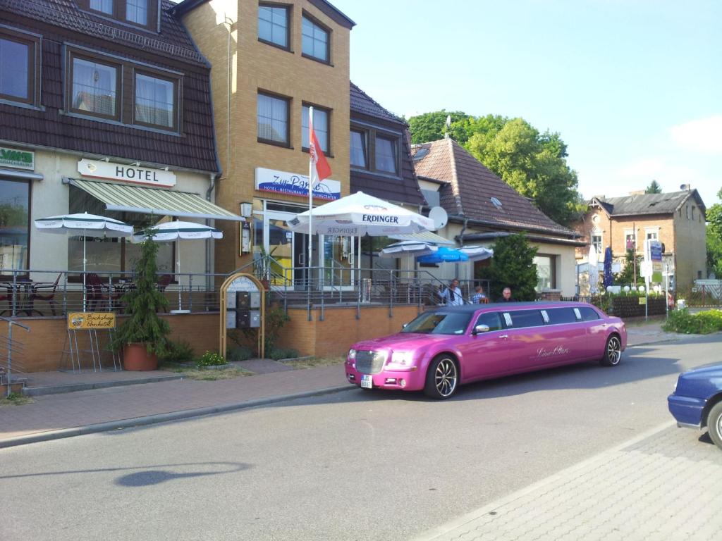 een roze auto geparkeerd voor een gebouw bij Hotel "Zur Panke" in Kolonie Röntgental