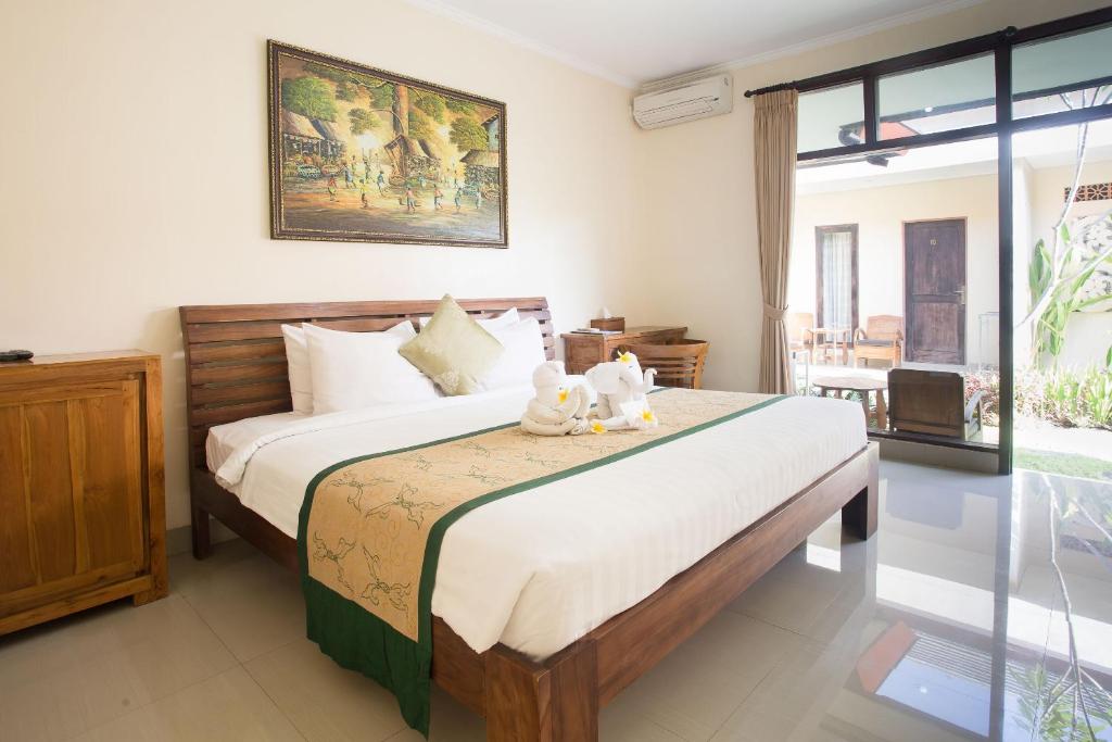 a bedroom with a bed with two teddy bears on it at Blanjong Homestay by ecommerceloka in Sanur
