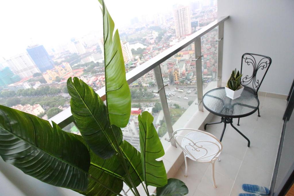 a room with a balcony with a table and a plant at Shendo Vinhomes Metropolis in Hanoi