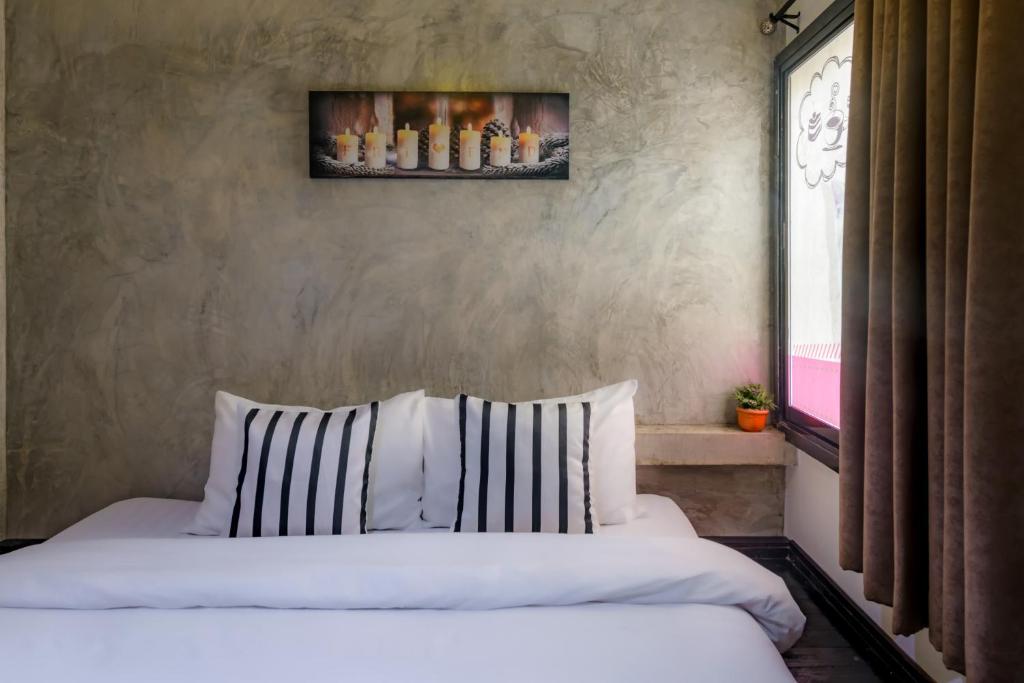a bedroom with two white beds and a window at Costa Bed Hua Hin in Hua Hin