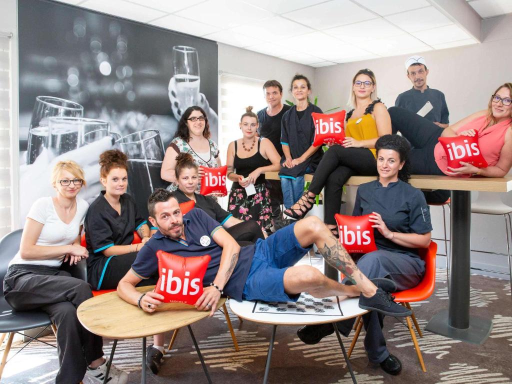 un grupo de personas sentadas en sillas con almohadas en ibis Sisteron, en Sisteron