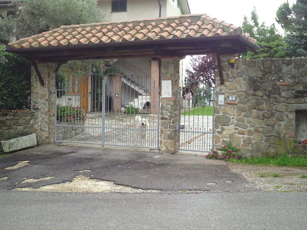 a gate to a house with a stone wall at B&B Casa Villa Siviglia in Marliana