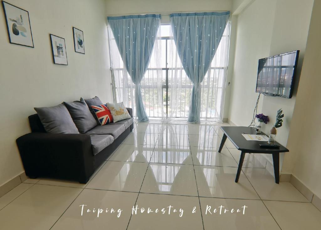 a living room with a couch and a table at Taiping Centre Point Suite 9 by BWC in Taiping