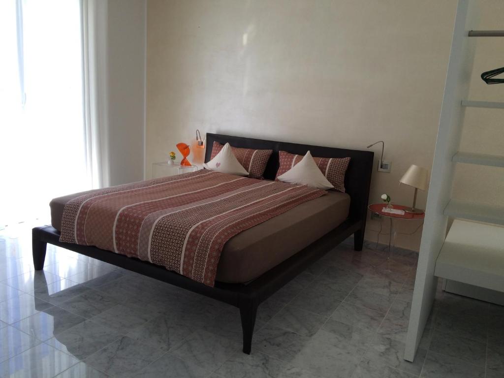 CossignanoにあるResidenza delle Grazieのベッドルーム1室(赤と茶色の毛布付きのベッド1台付)