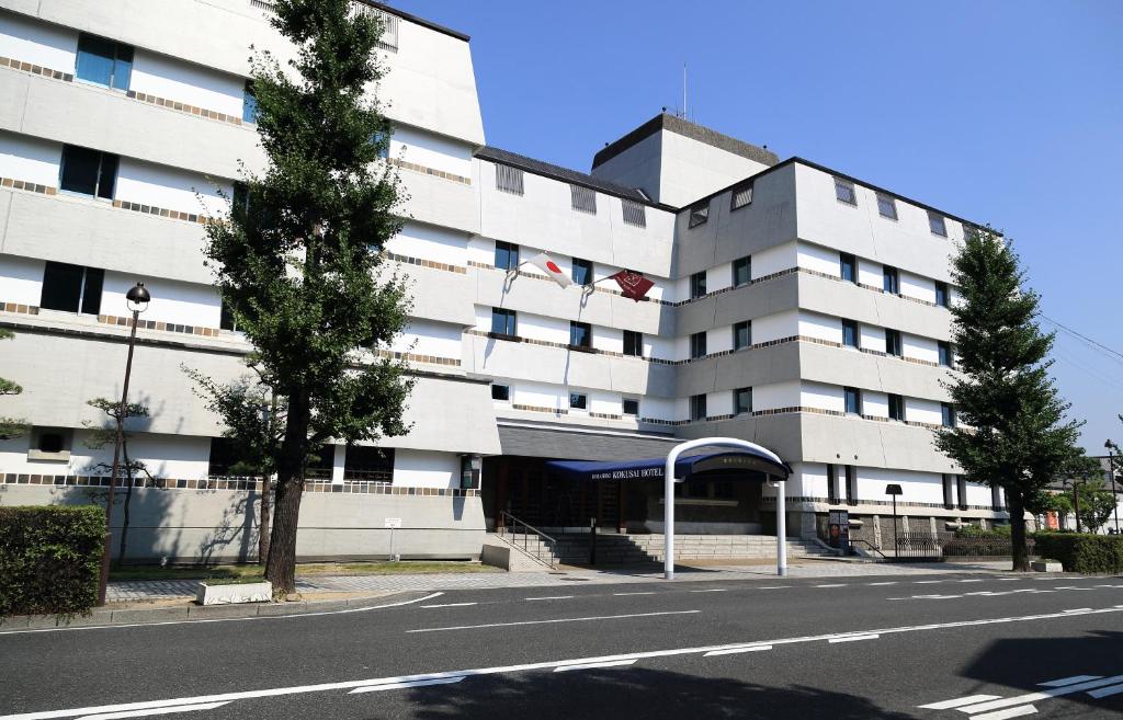 un gran edificio blanco con una calle delante en Kurashiki Kokusai Hotel en Kurashiki