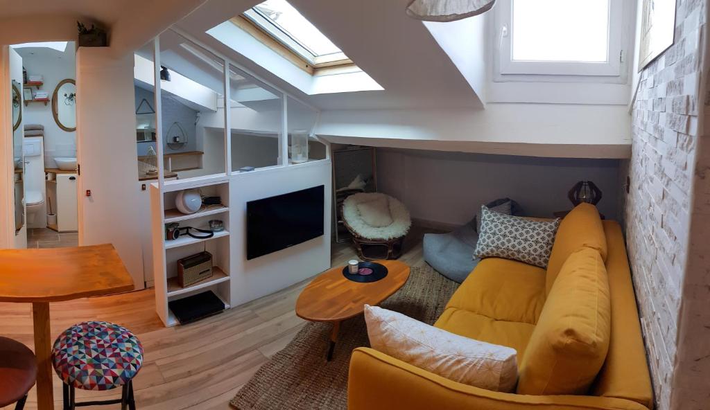 a living room with a yellow couch and a tv at Lovely Studio 1bdr City Center Studio La Tête dans Les Étoiles in Cannes