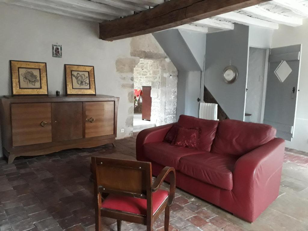 sala de estar con sofá rojo y silla en Galerie Benjamine, en Vézelay