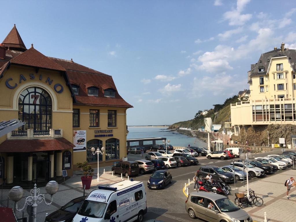 une rue avec des voitures garées devant un bâtiment dans l'établissement Charmant Studio en plein centre ville, à Granville