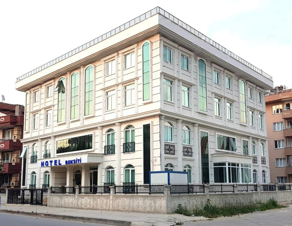 BEKSİTİ HOTEL في يالوفا: مبنى ابيض كبير شبابيكه خضراء على شارع