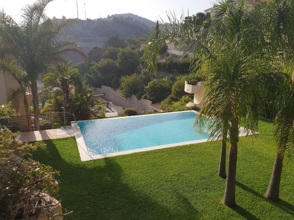 una piscina en un patio con palmeras en Bonita casa en Cotobro en Almuñécar