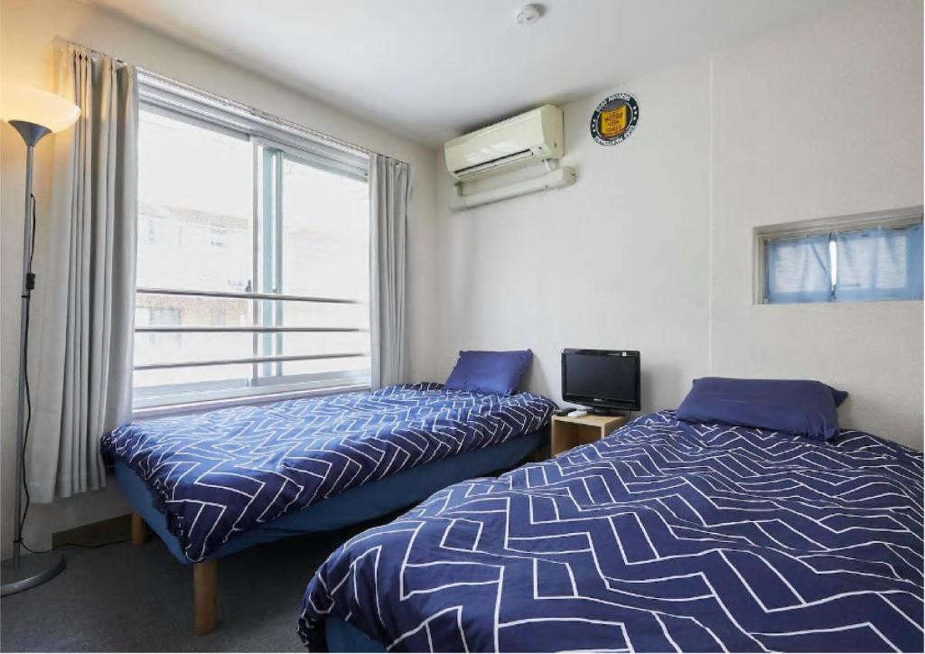 2 camas en una habitación con ventana en 2BR 4beds Shibuya Shinjuku Harajuku 10min wifi, en Tokio