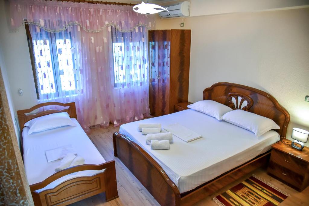 1 dormitorio con 2 camas con sábanas blancas en Hotel Sofra, en Gjirokastra