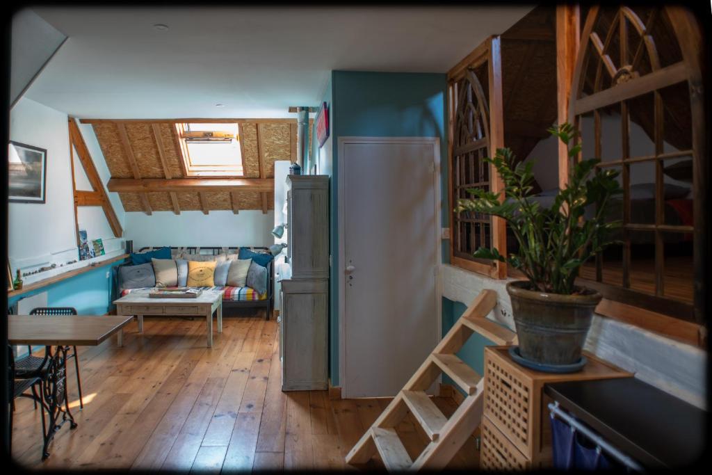 a kitchen and living room with a refrigerator and a table at Grand studio duplex proche de la mer in Fécamp