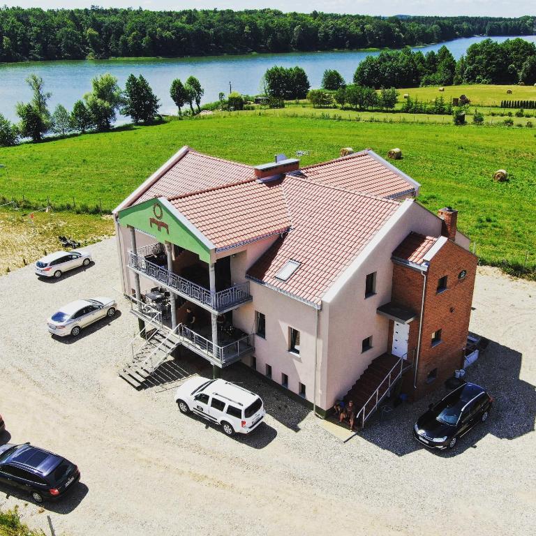a large house with cars parked in front of it at Nad Sunowem Lake House in Chrzanowo