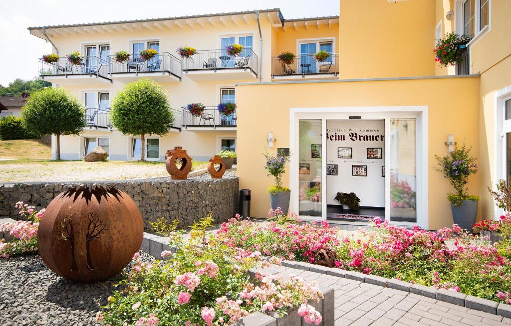 um edifício com flores em frente em Brauers Landarthotel GmbH em Daun