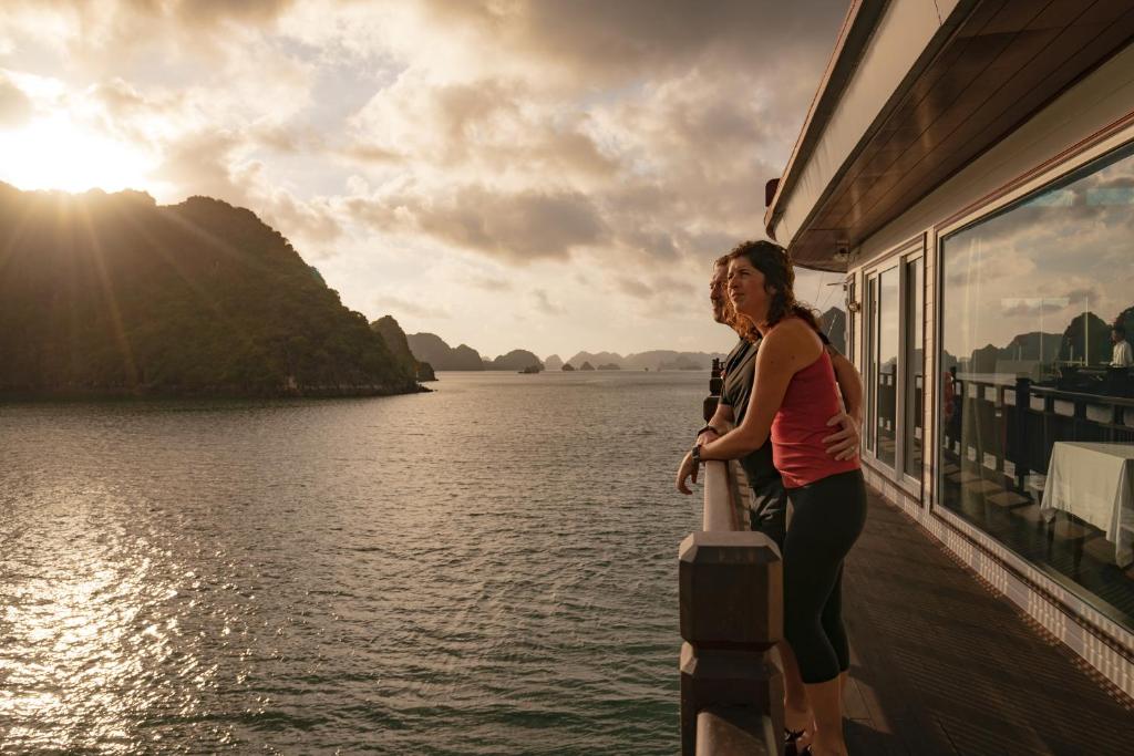 a woman standing on a boat looking out at the water at Heritage Line Ginger Cruise - Halong Bay & Lan Ha Bay in Ha Long