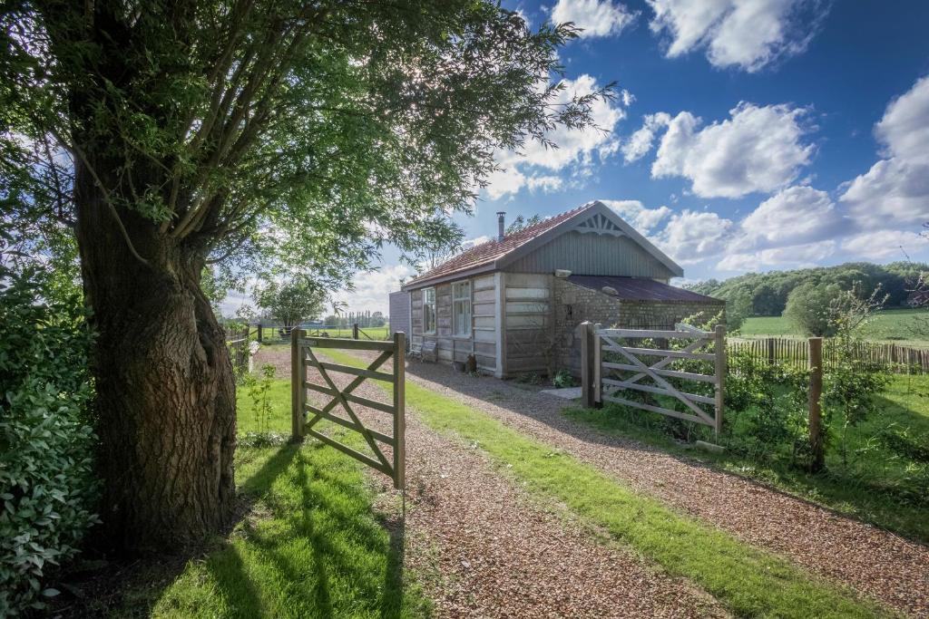 a barn in a field with a fence and a tree at Barak de Vinck in Ypres