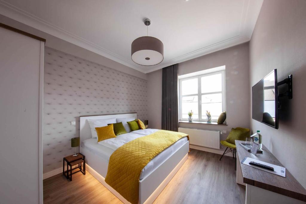 - une chambre avec un lit et une couverture jaune dans l'établissement Altes Amtshaus, à Reken