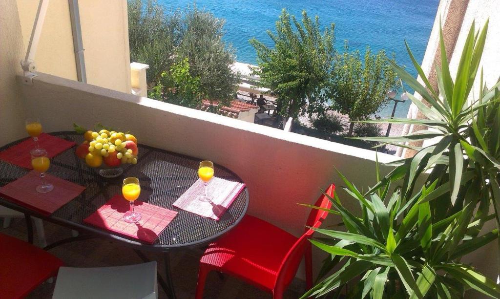 a table and chairs on a balcony with a view of the ocean at Apartments Malina in Tučepi