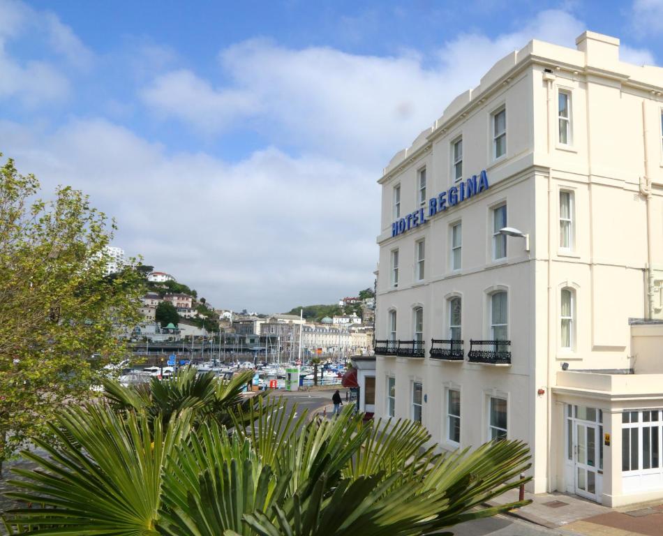 a white building with a sign on the side of it at Regina Hotel in Torquay